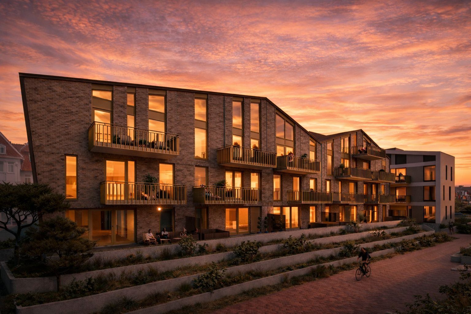 Impressie van de gevel van Strand Residence bij zonsondergang, met verlichte appartementen en balkons
